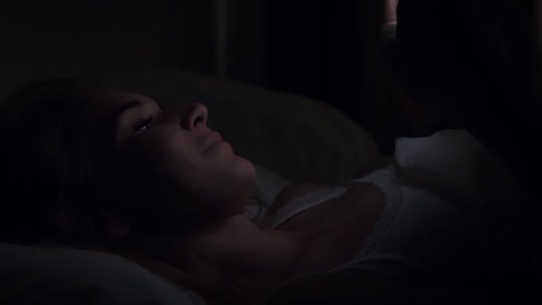 Kobieta za pomocą smartfona na łóżku przed snem w nocy. — Wideo stockowe