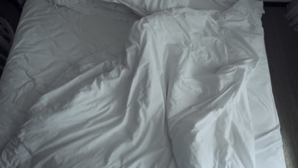 Cama arrugada desordenada con ropa de cama blanca . — Vídeos de Stock