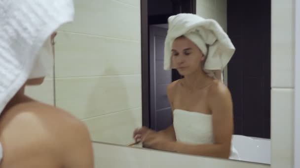 Νεαρή γυναίκα εφαρμόζοντας μάσκαρα στις βλεφαρίδες στο μπάνιο. — Αρχείο Βίντεο
