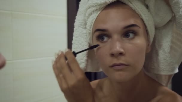 Junge Frau trägt Wimpern im Badezimmer mit Mascara auf. — Stockvideo