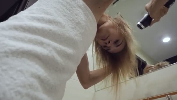 Beautiful woman drying hair with blow dryer after taking shower in bathroom. — Stockvideo