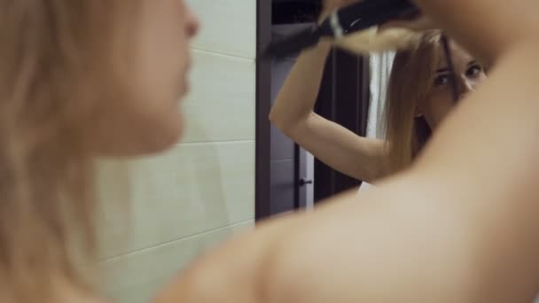 Женщина сушит волосы щеткой после принятия душа в ванной . — стоковое видео