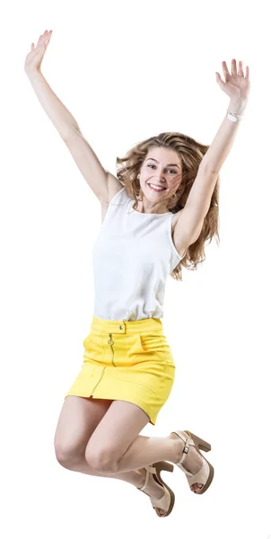 Happy young woman in yellow skirt jumps up. — Stock Photo, Image