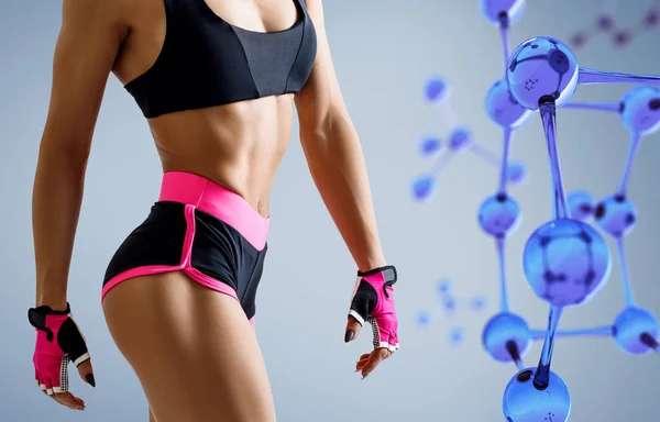 Mulher atlética em pé perto da cadeia de moléculas de vidro azul . — Fotografia de Stock