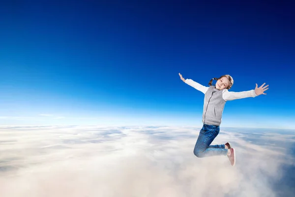 青空の雲の上を飛ぶ少女. — ストック写真