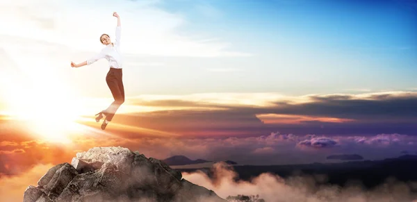 Happy business woman jumps up on mountain peak. — Stock Photo, Image