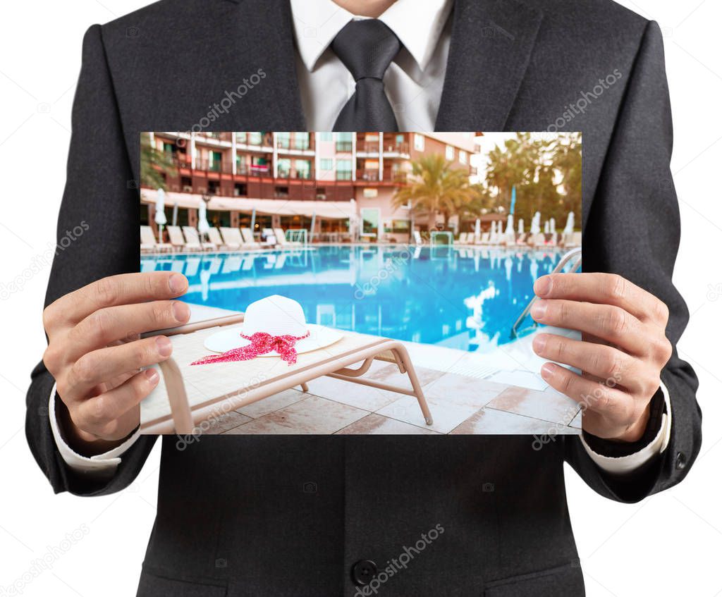Businessman holds placard with photo of vacation scenery.