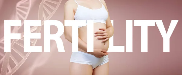Mujer embarazada acaricia el vientre entre entre los tallos de ADN y palabra grande FERTILIDAD — Foto de Stock