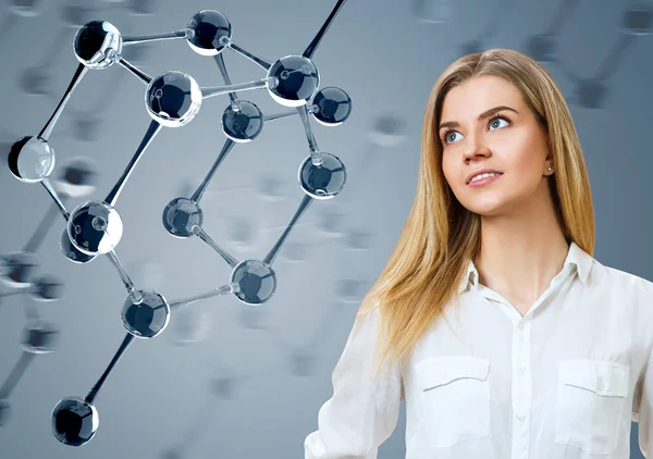 Young woman looking on glass molecules. — Stock Photo, Image