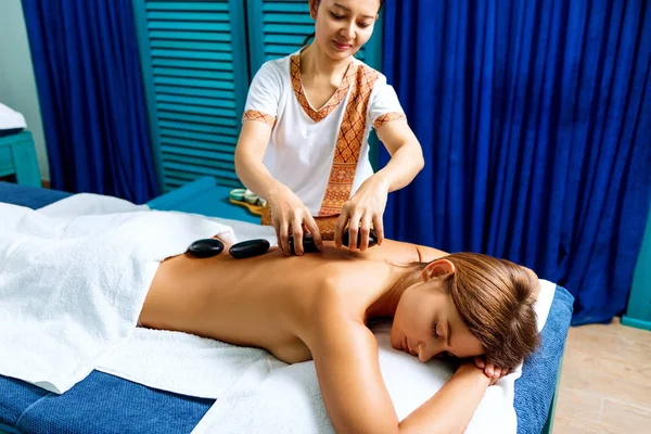 Thai therapist doing massage with hot stones. — Stock Photo, Image