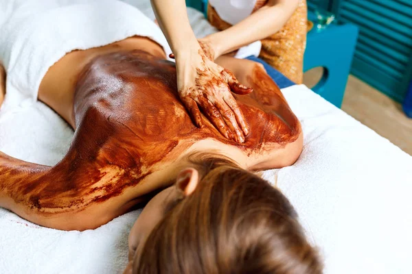 Massagem nas costas com máscara hidratante de chocolate . — Fotografia de Stock