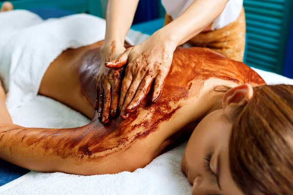 Back massage with chocolate moisturizing mask. — Stock Photo, Image