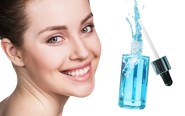 Bellissimo viso di giovane donna vicino bottiglia cosmetica blu . — Foto Stock