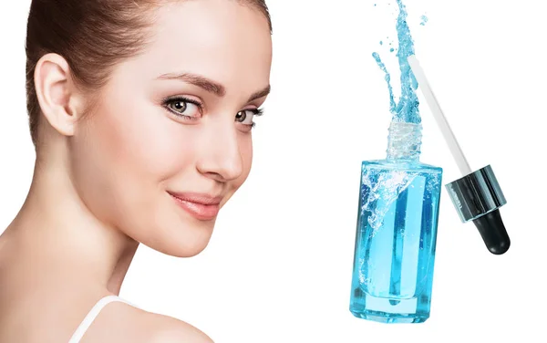Rosto bonito de mulher jovem perto de garrafa cosmética azul . — Fotografia de Stock