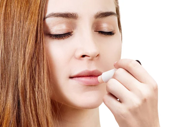 Hermosa mujer aplicando bálsamo labial higiénico . — Foto de Stock