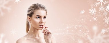 Kar taneleri ile bej arka plan üzerinde genç kadın.