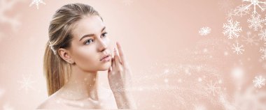 Kar taneleri ile bej arka plan üzerinde genç kadın.