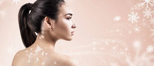 Jovem mulher sobre fundo bege com flocos de neve . — Fotografia de Stock