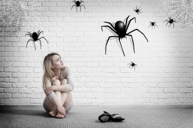 Woman sitting on the floor and looking on imaginary spider. clipart