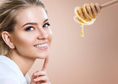 Genç kadın ve bal kaşığı yüz maskesi hazırlamak.