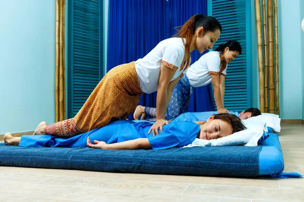 Twee Thaise masseuses synchroon doen Thaise massage. — Stockfoto