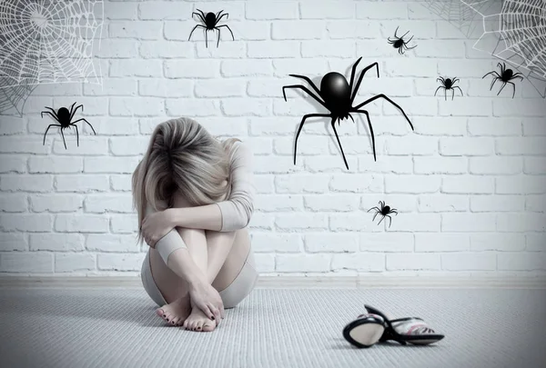 床に座って想像上のクモを見ている女性. — ストック写真