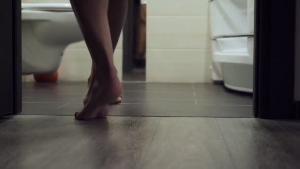 バスルームに入る女性は、彼女のパンティーを脱いで、シャワーに行きます. — ストック動画