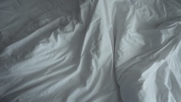 Unaufgeräumtes zerknülltes Bett mit weißer Bettwäsche. — Stockvideo