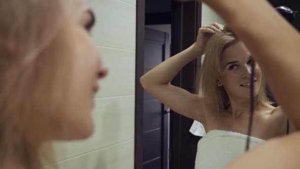 Bella donna asciugatura capelli con phon pennello dopo aver preso la doccia in bagno . — Video Stock