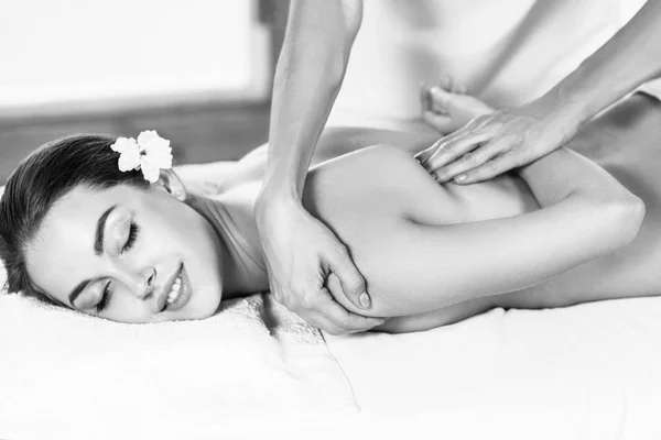 Piękna kobieta leżąca na stole do masażu i ciesząc się masażem. — Zdjęcie stockowe