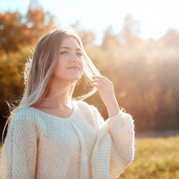Hezká dívka pózná na kameře a slunného podzimní den. — Stock fotografie