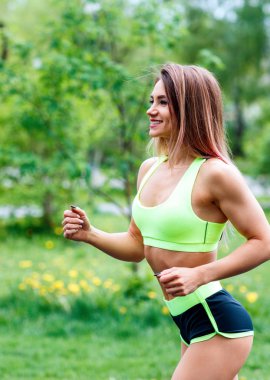 Yeşil yaz parkında çalışan güzel genç kadın.