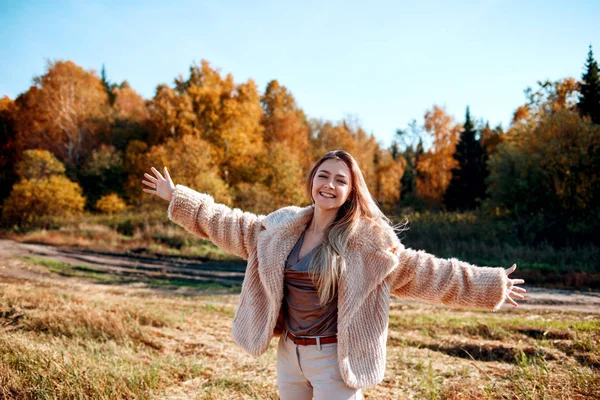 Menina alegre com as mãos levantadas no campo na estação quente do outono . — Fotografia de Stock