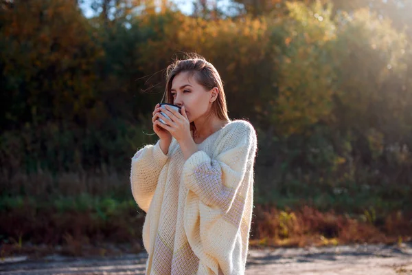 Beautiful admiring woman drinking hot tea from thermos cup — Stock Photo, Image