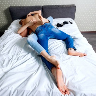 Yatakta oynayan genç çift üzerinde üst görünümü.