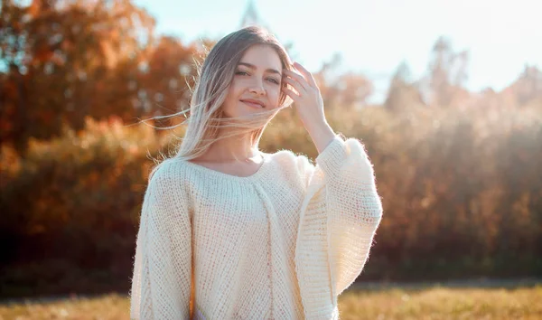 Chica bonita posando en la cámara y disfrutando de un día soleado de otoño . — Foto de Stock