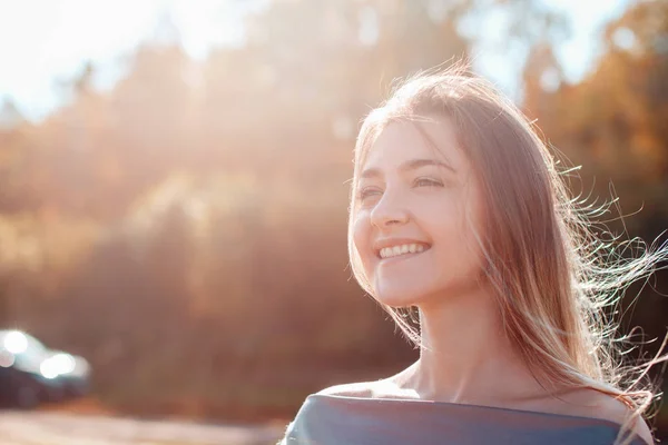 Mooi meisje poseren op camera en genieten van zonnige herfst dag. — Stockfoto