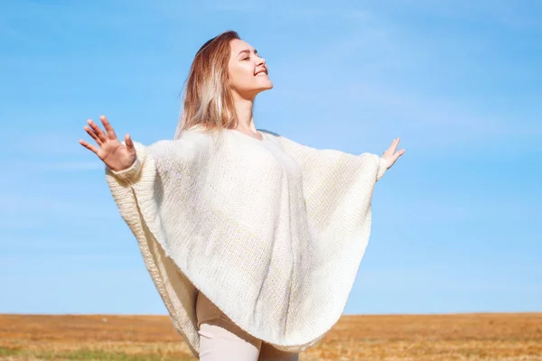 Cheerful girl with raised hands on the field in warm autumn season. — Stock Photo, Image