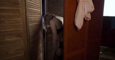 Seksi kadın ahşap katlanır ekran arkasında onu çorap düzeltir.