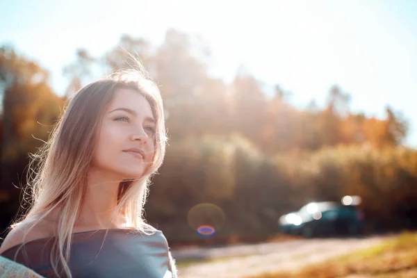 Hezká dívka pózná na kameře a slunného podzimní den. — Stock fotografie