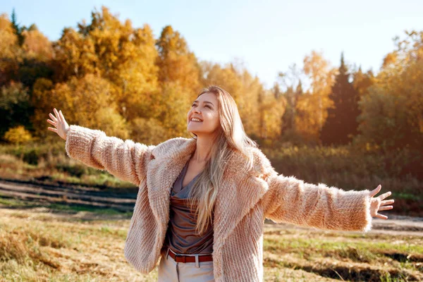 在温暖的秋天，在田野上举手的欢快的女孩. — 图库照片
