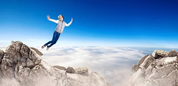 Little cute girl falling from the mountain peak. — Stock Photo, Image