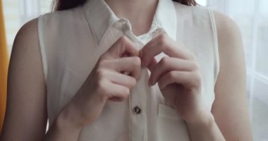 Tanınmayan kadın evde beyaz bluz unbuttoning.