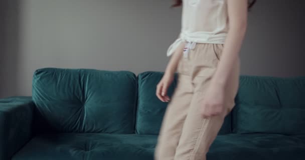 Redhead tired woman falling on sofa at home with a headache. — Stock Video