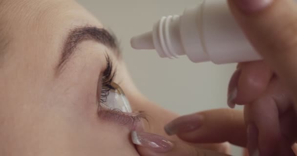 Young woman drops eyes with eyedropper. — Stock Video