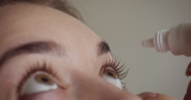 Jeune femme baisse les yeux avec compte-gouttes . — Video