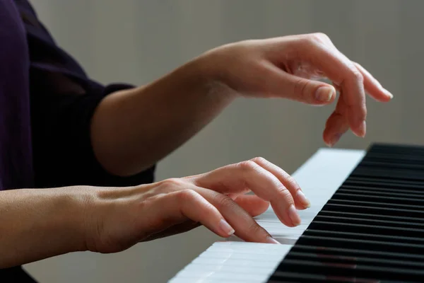 Jovem mulher tocando piano — Fotografia de Stock