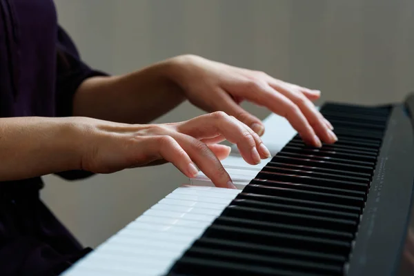 Jovem mulher tocando piano — Fotografia de Stock