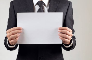 Metin alanı için boş bir beyaz levha tutan işadamı.