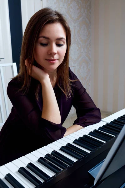 Mujer joven tocando el piano electrónico en casa . — Foto de Stock